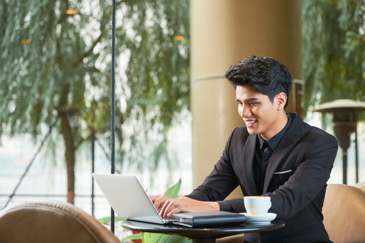 cheerful entrepreneur working laptop cafe