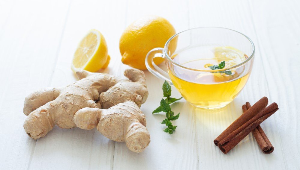 glass cup hot tea with ginger lemon mint cinnamon white wooden table