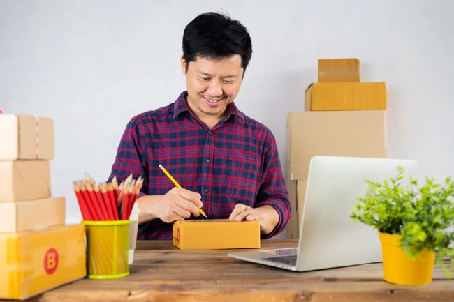 parcel box desk with man making notes back scaled